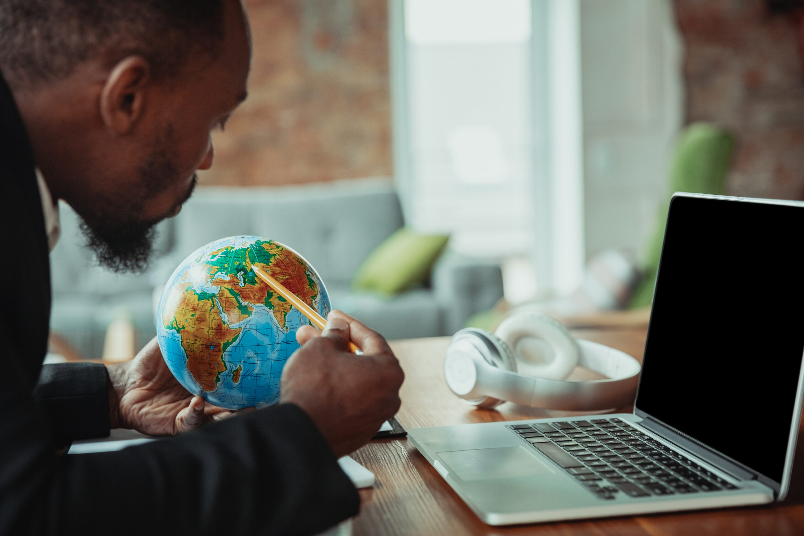 Businessman or student working from home African-american man using laptop, tablet and headphones. Online conference, lesson, remote office.