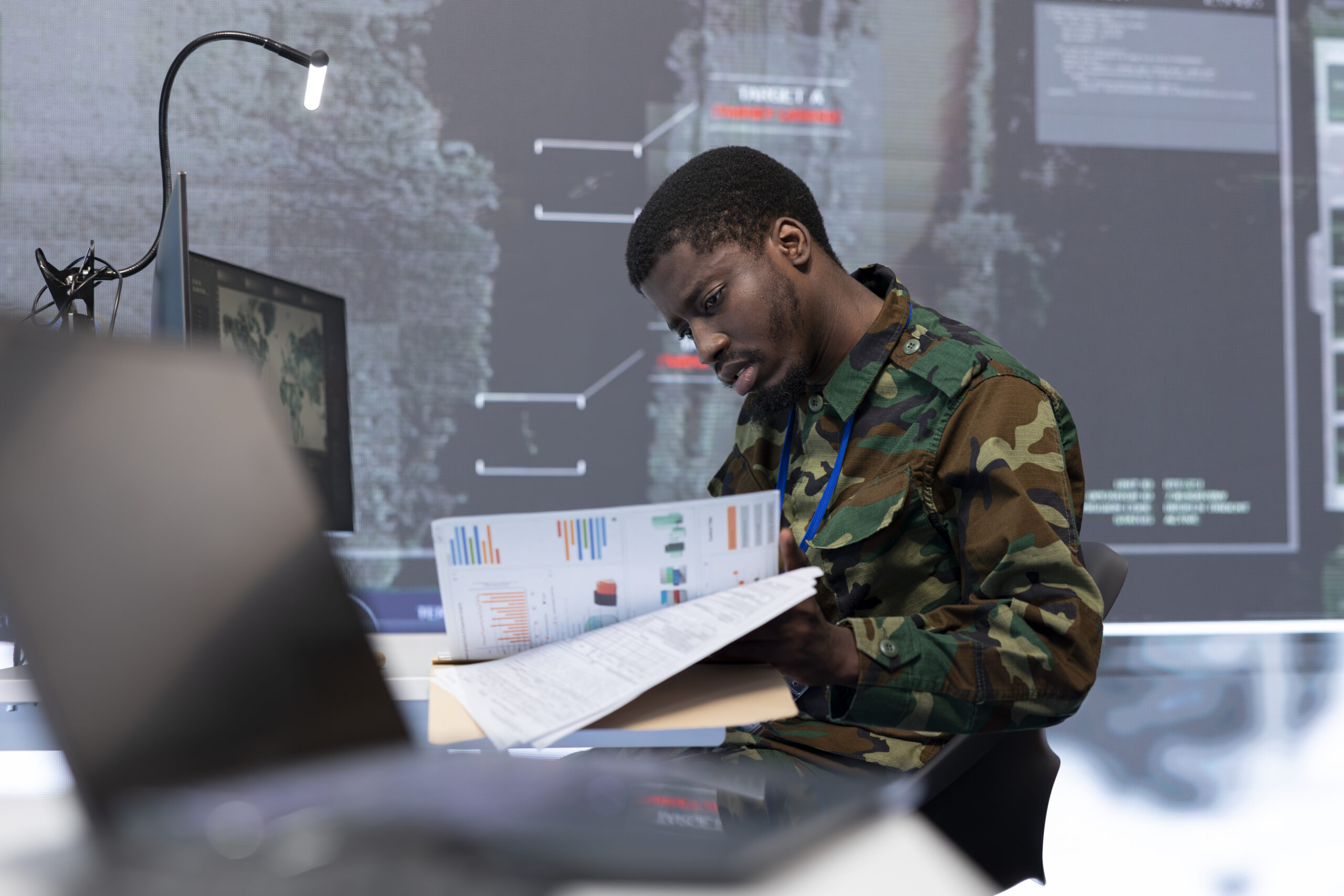 Military team manages cybersecurity operations in a high tech control center base of operations, ensuring data protection and managing surveillance systems, safeguarding national security.